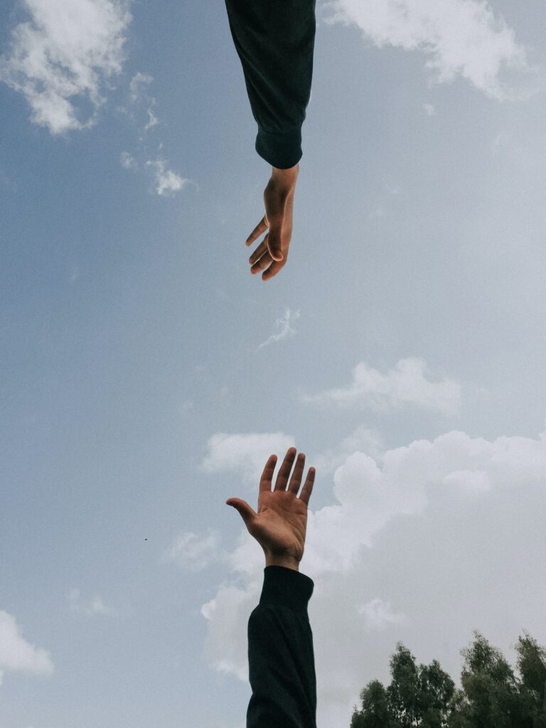 Zwei Hände greifen nach einander und zeigen, wie wichtig Werte wie Zusammenarbeit sind.