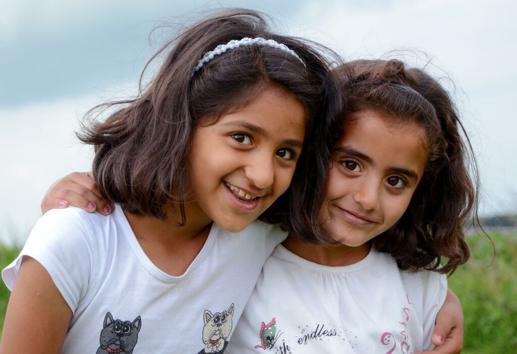 Zwei junge, lächelnde Mädchen, die von einem unserer Projekte unter Muslime profitieren.
