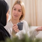Zwei Frauen im Gespräch miteinander bei der eine junge Frau ihren Glauben mit einer Muslima teilt.
