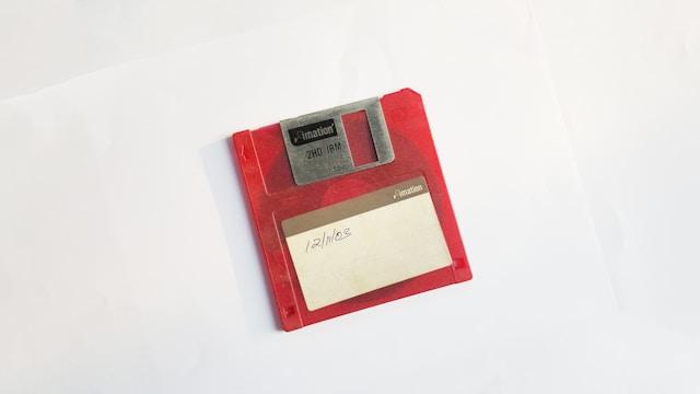 Das Bild zeigt eine rote Diskette und symbolisiert die Produktion von Medien.